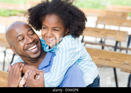 Père et fille smiling on park bench Banque D'Images