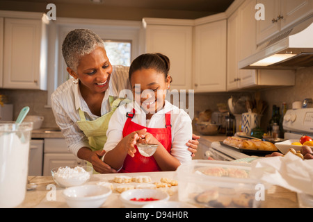 Woman and granddaughter baking in kitchen Banque D'Images