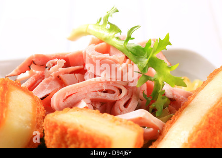 Salade verte garnie de tranches de jambon et fromage frit Banque D'Images