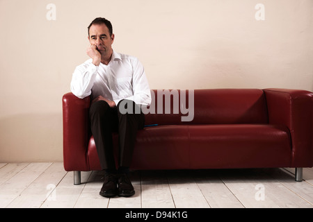 Man Sitting on sofa et d'attente Banque D'Images