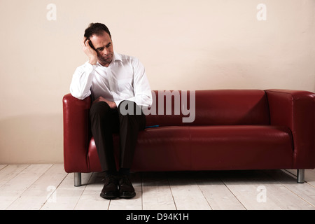 Man Sitting on sofa et d'attente Banque D'Images