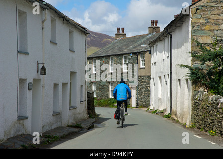 Cycliste dans le village de Rosthwaite, Borrowdale, Parc National de Lake District, Cumbria, Angleterre, Royaume-Uni Banque D'Images