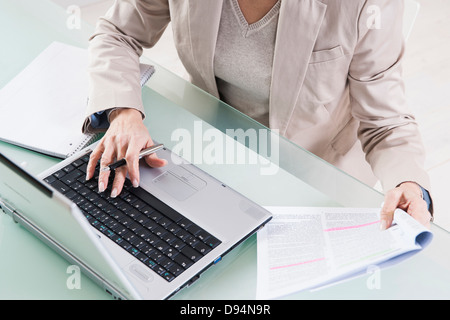 Mature Woman working on Laptop in Office Banque D'Images