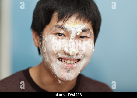 Les hommes de manger un morceau de gâteau enduit de crème glacée Banque D'Images