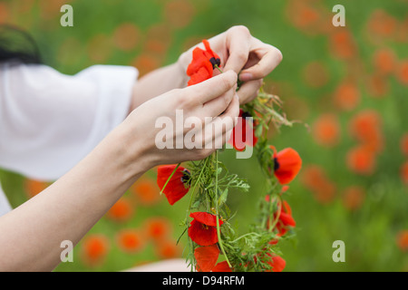 Ses mains tissu de fleurs, couronne de fleurs. Sur le terrain Banque D'Images