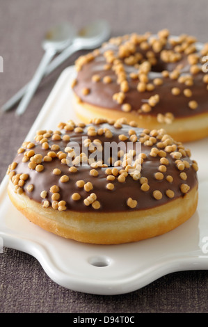 Close-up de Caramel Donuts on Cutting Board on grey background, Studio Shot Banque D'Images