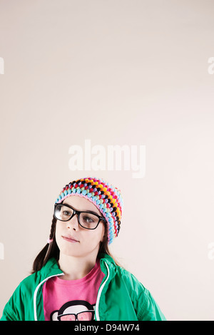 Portrait of Girl wearing Woolen Hat et Horn-rimmed lunettes, à la recherche sur le côté, Studio Shot on White Background Banque D'Images