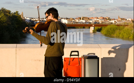 Street artiste musicien ambulant joue un violon sur le pont romain de Cordoue en Andalousie, au coucher du soleil Andalousie Espagne Europe Banque D'Images