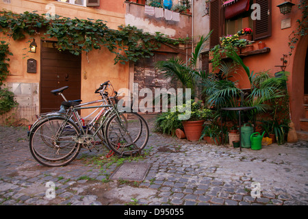 Calme à l'écart courtyard à Rome avec des plantes en pot et des vélos Banque D'Images