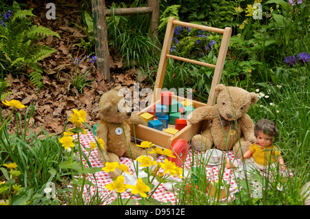 Tea party avec des jouets dans le ce qui va nous quitter ? Jardin de l'enfance NSPCC magique au RHS Chelsea Flower Show 2013, Londres, Royaume-Uni. Banque D'Images