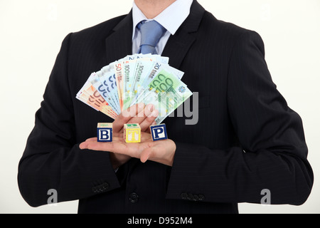 Businessman holding factures et blocs de jouets Banque D'Images