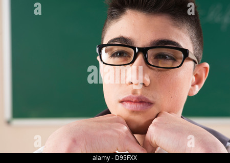 Close-up Portrait of Boy Wearing Glasses in Classroom Banque D'Images