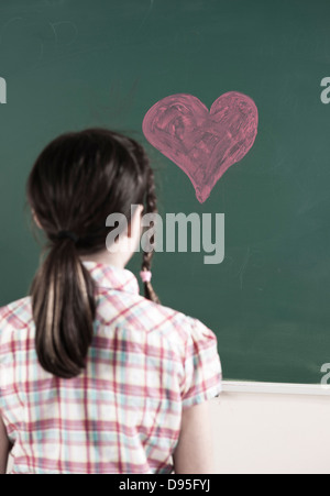 De retour à la fille de Cœur dessiné à la craie sur tableau noir en classe Banque D'Images