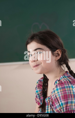 Portrait of Girl in front of Chalkboard in Classroom Banque D'Images