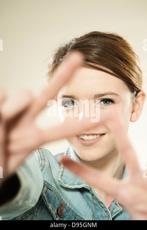Portrait of Teenage Girl faisant le signe de la paix avec ses doigts, en studio Banque D'Images