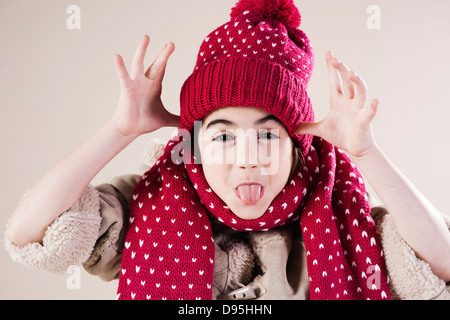 Portrait of Girl making faces wearing Hat and Scarf in Studio Banque D'Images