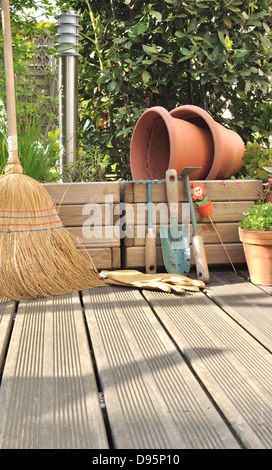 Différents accessoires de jardinage et de nettoyage sur une terrasse en bois Banque D'Images