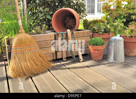 Différents accessoires de jardinage et de nettoyage sur une terrasse en bois Banque D'Images