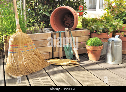 Différents accessoires de jardinage et de nettoyage sur une terrasse en bois Banque D'Images