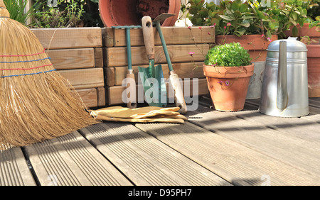 Différents accessoires de jardinage et de nettoyage sur une terrasse en bois Banque D'Images