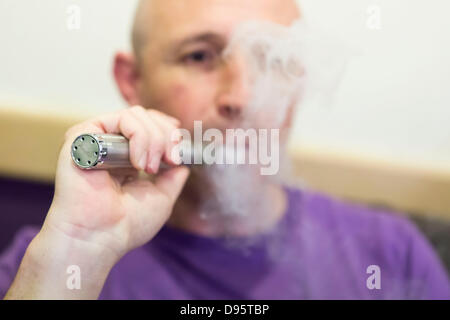 Swansea, Pays de Galles, Royaume-Uni. 12 juin 2013. Le personnel de la direction générale de la ville de Swansea vapeurs, un fournisseur de cigarettes électroniques et fluide, la démonstration de l'utilisation de 'vaping" appareils. En vertu de nouvelles propositions par la Medicines and Healthcare Products Regulatory Agency (MHRA), les cigarettes électroniques sont d'être classés comme 'medicines'. Les vapeurs sont dynamiques une société galloise avec leur siège social à Carmarthen. Crédit : John Wellings/Alamy Live News Banque D'Images