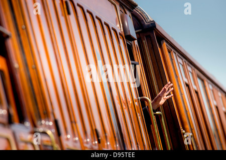 Les Bluebell Railway dans l'East Sussex, Royaume-Uni. Le premier indicateur standard de fer vapeur.Un garde de préservation des vagues d'une porte. Banque D'Images