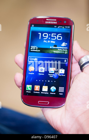 Hand holding smartphone Samsung S3, Close up Banque D'Images