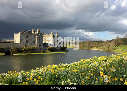 Le Château de Leeds dans le Kent, Royaume-Uni avec floraison des jonquilles et ciel dramatique. Banque D'Images