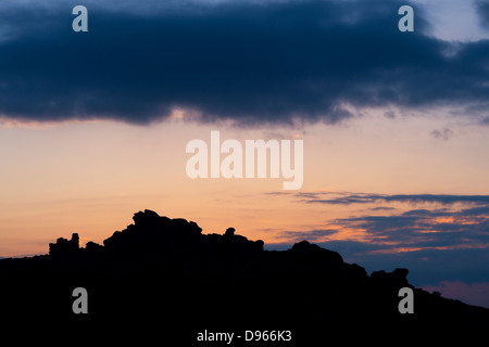 Hound Tor au coucher du soleil. Silhouette. Dartmoor National Park, Devon, Angleterre Banque D'Images