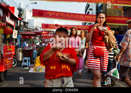 Fat boy eating sur rue dans les fêtes de fin d'année dans le quartier chinois de Bangkok Banque D'Images