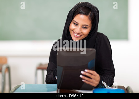 Belle Arabian teenage girl using tablet computer in classroom Banque D'Images