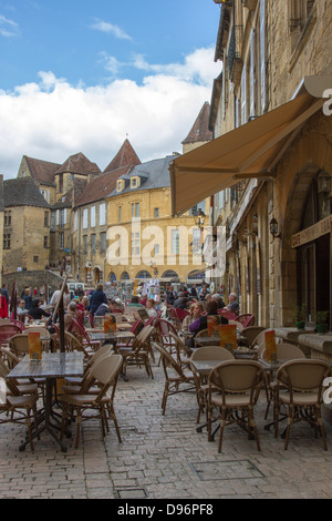 Les touristes de manger à la terrasse d'un café à Liberty Plaza, dans le centre de la charmante ville de Sarlat, Dordogne France Banque D'Images