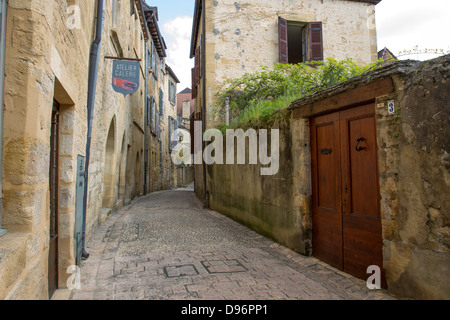 Panneaux de porte en grès mur le long de rue pavée de charmante ville médiévale de Sarlat, Dordogne France Banque D'Images