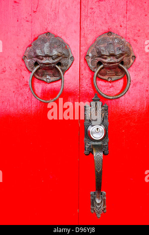 Porte chinoise rouge avec un lion/tête de dragon. Banque D'Images