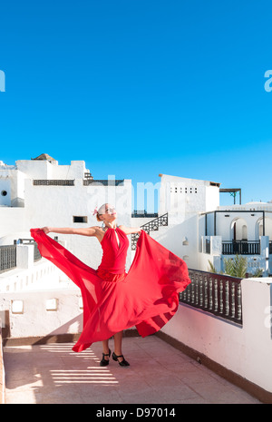 Danseuse de flamenco traditionnel attrayant portant robe rouge avec une fleur dans ses cheveux Banque D'Images