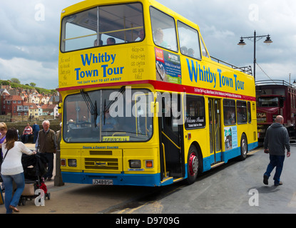 Un jaune vif garni ouvert bus à impériale qui emmène les touristes sur un tour autour de la station balnéaire de Whitby Banque D'Images