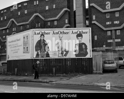 Homme marchant passé thésaurisation publicité sur Coldharbor Lane, Brixton en 1981. Dans l'arrière-plan est la nouvelle Maison Southwyck Banque D'Images