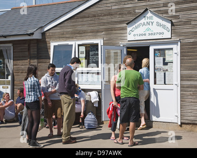 File d'attente de personnes extérieures à l'entreprise Shed restaurant de poissons, West Mersea, Mersea Island, Essex, Angleterre Banque D'Images