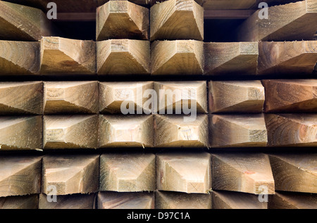 Les poteaux de clôture en bois empilés dans un builder's merchant yard, UK Banque D'Images