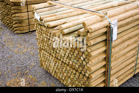 Les poteaux de clôture en bois empilés dans un builder's merchant yard, UK Banque D'Images