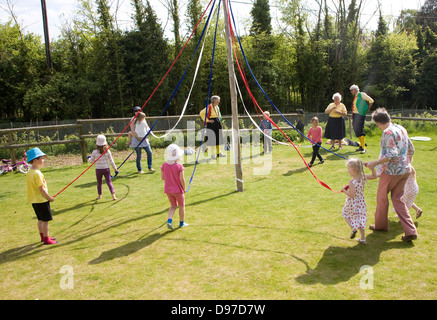 Les enfants de la danse autour d'un mât à un festival country, Shottisham, Suffolk, Angleterre Banque D'Images