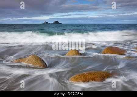 Vagues tourbillonnent autour des rochers sur la plage de Porth Nanven, Cornwall, Angleterre. Banque D'Images