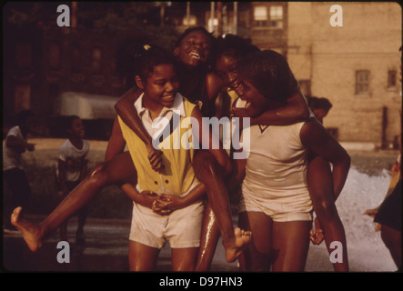 Les jeunes Noirs se rafraîchir avec de l'eau d'incendie sur le côté sud de Chicago dans la Communauté Woodlawn, 06/1973 Banque D'Images
