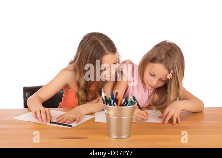 Grande soeur essaie de copier le dessin de sa petite sœur. Isolé sur un fond blanc. Banque D'Images