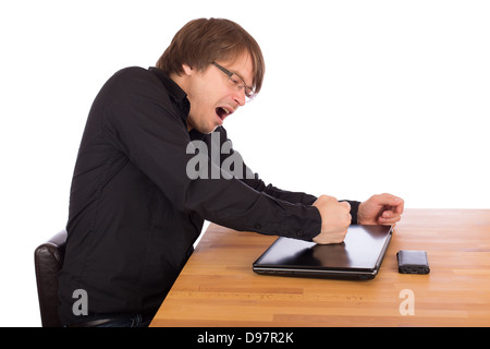 Homme en colère frapper avec son poing sur son ordinateur portable. Isolé sur un fond blanc. Banque D'Images