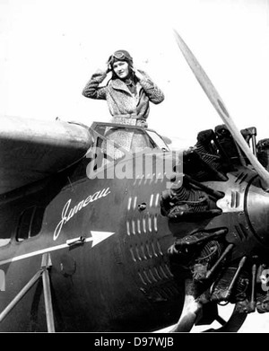 Femme dans un cheetah manteau, casque et lunettes aviator, debout dans le cockpit d'avion ponton, probablement l'État de Washington Banque D'Images