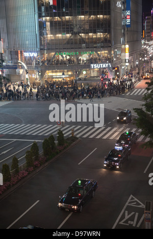 Croisement de Shibuya est célèbre pour brouiller crossing à Tokyo City, Japon. Vue de nuit. Personnes debout et feu vert d'attente Banque D'Images