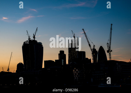 LONDRES, Royaume-Uni — la silhouette changeante de Londres est dramatiquement dessinée sur un ciel sombre, mettant en valeur la construction en cours de nouveaux gratte-ciel. Cette image saisissante reflète la croissance dynamique et l'ambition architecturale de la ville, avec les contours des immeubles en hauteur émergeants qui côtoient des monuments établis, symbolisant la transformation continue de Londres en tant que centre financier et culturel mondial. Banque D'Images