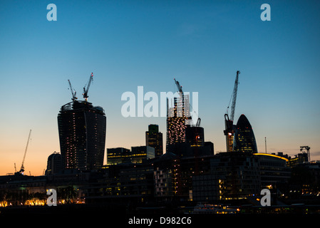 LONDRES, Royaume-Uni — la silhouette changeante de Londres est dramatiquement dessinée sur un ciel sombre, mettant en valeur la construction en cours de nouveaux gratte-ciel. Cette image saisissante reflète la croissance dynamique et l'ambition architecturale de la ville, avec les contours des immeubles en hauteur émergeants qui côtoient des monuments établis, symbolisant la transformation continue de Londres en tant que centre financier et culturel mondial. Banque D'Images