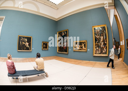 Exposition de peinture des musées royaux des Beaux-Arts Bruxelles Belgique / BRUXELLES, Belgique — les visiteurs peuvent admirer des peintures classiques dans une galerie des musées royaux des Beaux-Arts de Belgique. Les toiles religieuses monumentales, dont le martyre de Saint Sébastien visible à droite, font partie de la collection Oldmasters Museum de l'institution. Cette aile se concentre sur des chefs-d'œuvre européens du XVe au XVIIIe siècle, une période dominée par les primitifs flamands de la région et les maîtres baroques ultérieurs, dont Rubens, Van Dyck et Jordaens. Banque D'Images